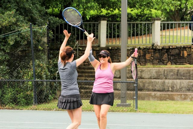 Two female tennis players celebrating a win