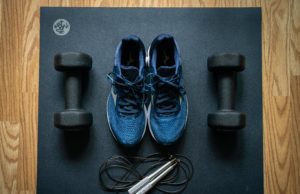 Get Strong For Tennis Yoga mat with sneakers, jump rope, and hand weights on top.