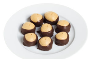 Peanut Butter Chocolate Tennis Balls A plate with eight buckeye cookies isolated on white