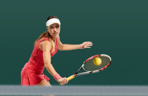 The Strike Zone Portrait of young fit happy sportswoman having tennis match on court