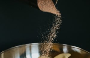 Awesome Apple Cake Chopped apples in a mixing bowl being covered in cinnamon