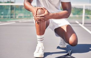 Unlock Your Full Potential Tennis, hands and knee in sports injury, accident or bruise holding painful area for medical emergency on the court. Hand of tennis player suffering from sore leg, fall or joint inflammation outside.