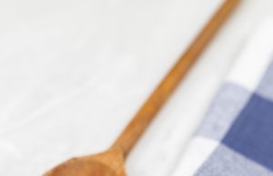 Greek Pasta Salad Raw pasta on the kitchen table with dishcloth wooden board knife and copy space.