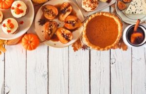 Performance Holiday Eating Autumn table scene top border of pies, appetizers and desserts, top view over a white wood background with copy space