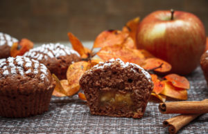 Paleo Apple Muffins Chocolate muffins with apple filling on a background of autumn leaves and cinnamon
