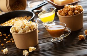 Caramel popcorn Paper buckets with butter and caramel popcorn on kitchen table