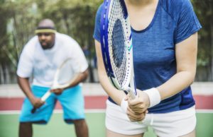 Playing Better Doubles Couple playing tennis as a team