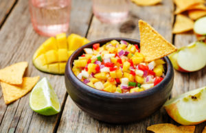 Zesty Pineapple & Mango Salsa apple mango salsa on a dark wood background. toning. selective Focus