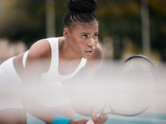 Mental Gymnastics Focused young woman waiting during a tennis match. African american woman ready to play a game of t.