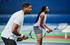 Elevating Atlanta’s Recreational Tennis Side view portrait of two young African American people playing tennis at indoor court, copy space