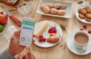 What’s New In Tracking Apps And Wearable Technology? Man examining the program on his phone before eating