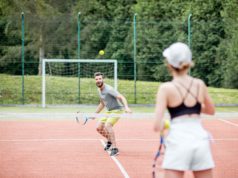 Developing A Growth Mindset Young couple in white sports wear playing tennis on the tennis court outdoors