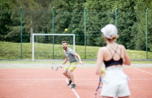 Developing A Growth Mindset Young couple in white sports wear playing tennis on the tennis court outdoors