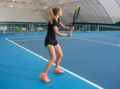 Instructing Tennis Students On Angles The young girl in a closed tennis court with ball and racket
