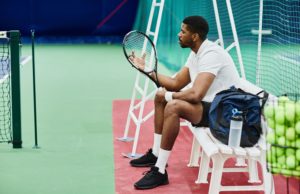 Secure A Win For Your Team Side view portrait of professional tennis player holding racket while taking break on bench in court, copy space