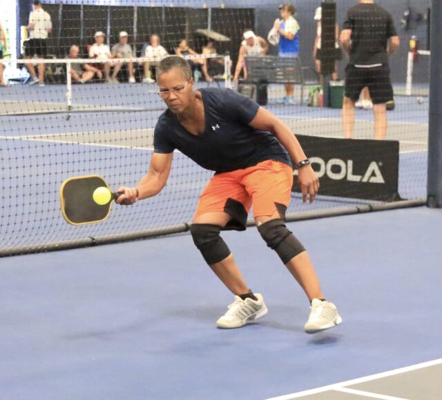 Pickleball player hitting the ball.