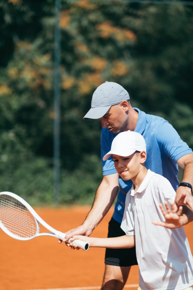 Tennis Training Tennis instructor with young boy in tennis training lesson