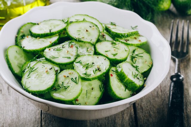 Cucumber salad. Fresh green cucumbers and dill salad bowl with olive oil
