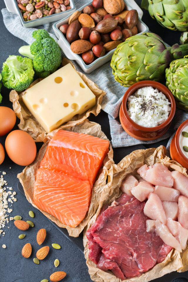 Assortment of healthy protein source and body building food. Meat beef salmon chicken breast eggs dairy products cheese yogurt beans artichokes broccoli nuts oat meal. Top view flat lay